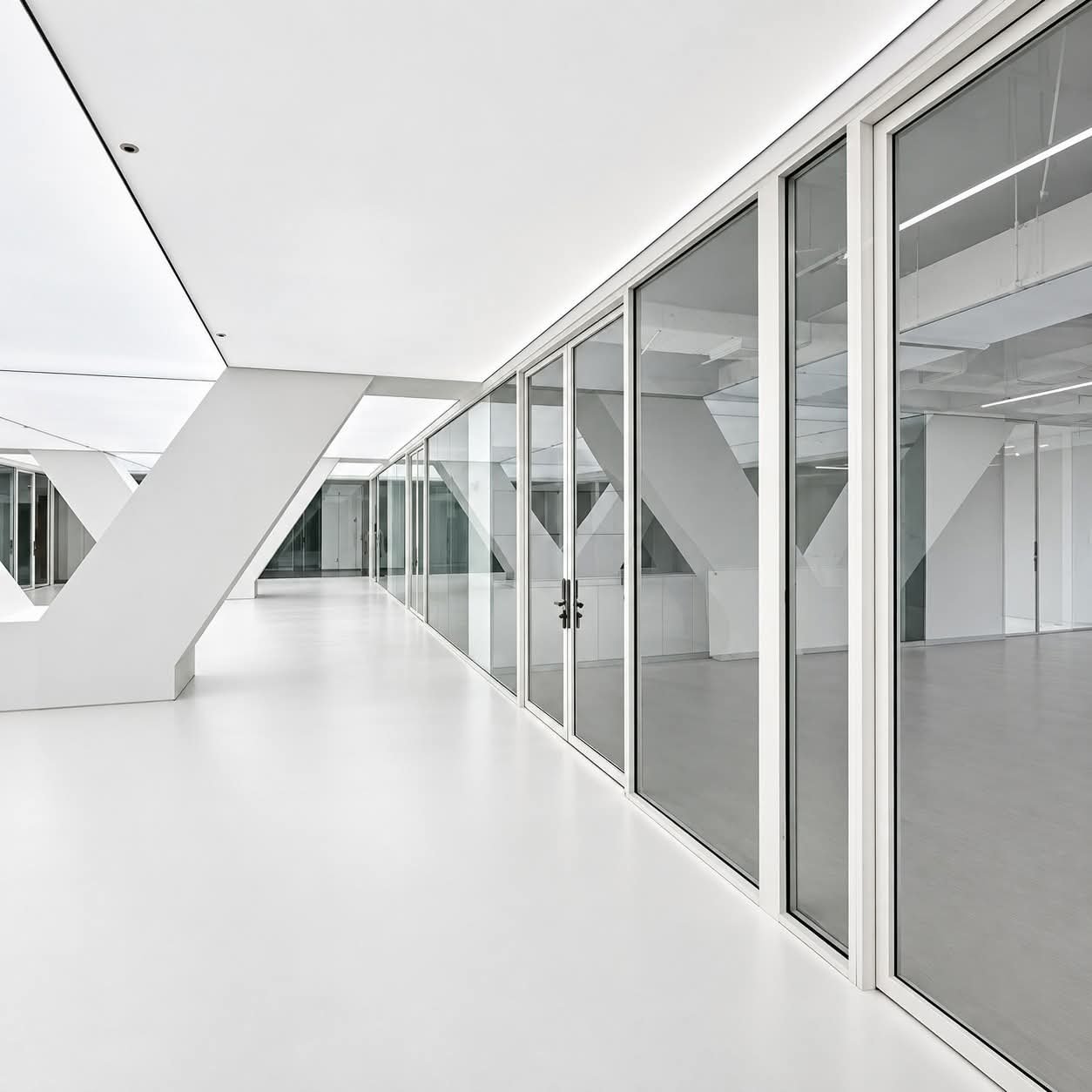 Glass partitions along a bright office corridor